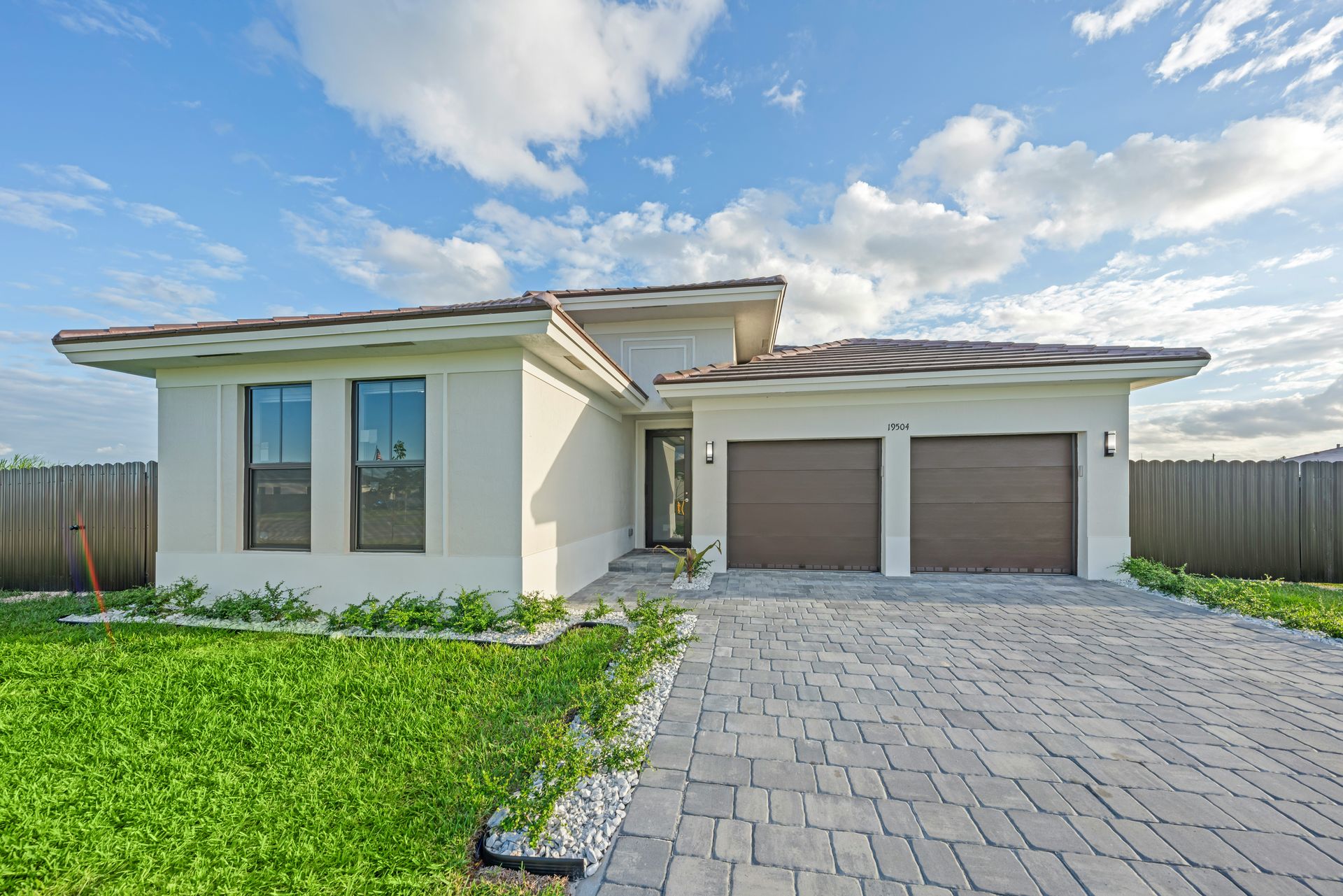 Modern house with a paved driveway and garage.